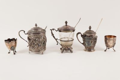 un ensemble d'objets en argent et en verre posés sur une surface blanche