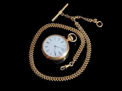 une image représentant une montre de poche en or avec une chaîne, sur fond noir