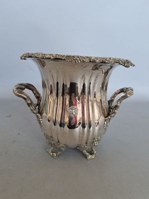 a silver vase that is sitting on a table