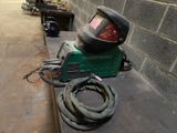 a welder that is sitting on a table next to a brick wall