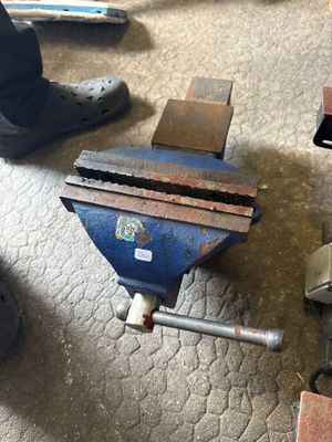 un étau bleu posé par terre à côté d'une paire de chaussures