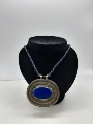un collier orné d'une pierre bleue sur un mannequin noir