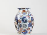 a white vase with blue and orange designs on it