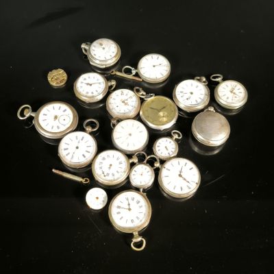 many different types of pocket watches on a black surface