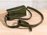 the small green bag is sitting on a wooden table