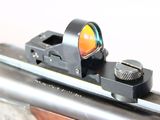 a close up of a rifle with a red dot on it