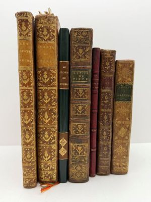 plusieurs vieux livres sont alignés sur une surface blanche