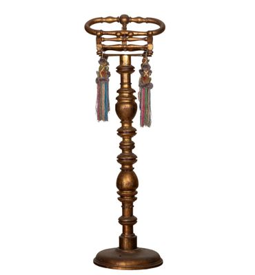 a gold metal table lamp with tassels hanging from it ' s base