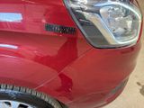 a close up of a red car with a sticker on it