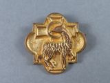 une image représentant une broche plaquée or ornée d'un lion