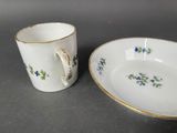 a close up of a cup and saucer on a table