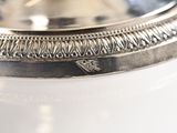 a silver plate on a white table with a black background
