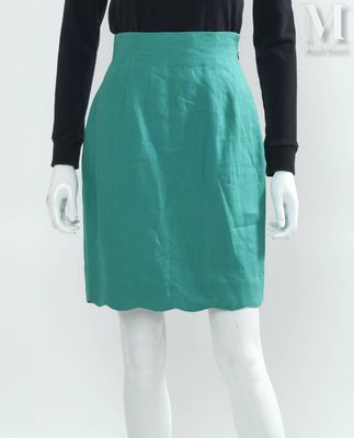 Le mannequin porte une jupe verte et un t-shirt noir.