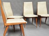 four mid century style dining chairs with upholstered seats and a foot stool