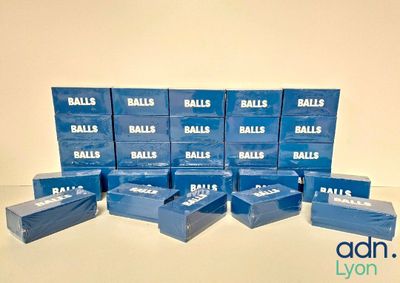 boxes of balls are stacked on top of each other on a table