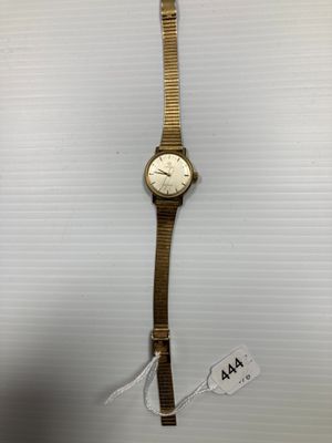 gros plan d'une montre-bracelet sur une surface blanche