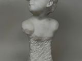 marble bust of a woman in a white dress on a gray background