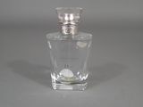 a bottle of perfume sitting on a table on a gray surface