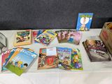 de nombreux livres pour enfants posés sur une table où se trouve une horloge