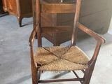 une chaise en bois avec une assise marron dans une pièce