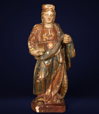 a wooden statue of a man holding a staff