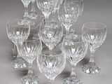 twelve crystal wine glasses on a grey background