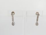 pair of diamond earrings on display on clear acrylic stand