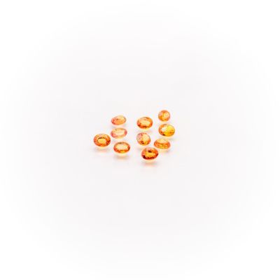 a group of orange glass beads sitting on top of a white surface