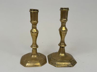 pair of antique brass candlesticks on a white background