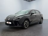 Une voiture grise est garée dans une grande pièce au sol noir.
