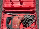 une boîte rouge contenant une perceuse et une cordelette