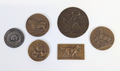 six médaillons en bronze de types et de tailles variés sur un fond blanc