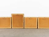four wooden boxes are lined up in a row on the floor