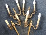 six antique brass wall sconces with white candles on a blue background