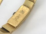 an image of a gold bracelet with a clasp on a white surface