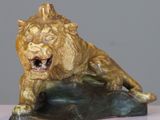statue of a lion on a rock on a white surface