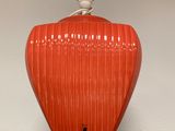 a red lamp that is on top of a shelf