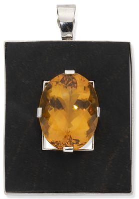 a close up of a pendant with a faceted citrine stone