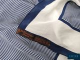 a close up of a blue and white striped shirt with a label on it