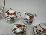 four pieces of tea set on a white table