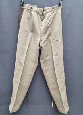 an old pair of pants hanging on a hanger on a wall