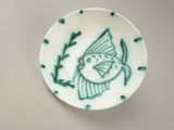 a small plate with a bird on it on a table