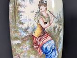 un vase avec un tableau posé sur une table
