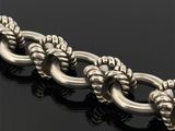 un gros plan d'une chaîne en argent sur une surface noire