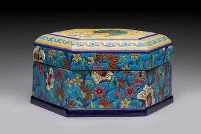une boîte bleue et jaune décorée de fleurs et de feuilles