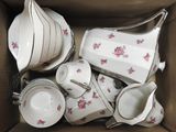 une boîte contenant tout un tas d'objets en porcelaine blancs et roses