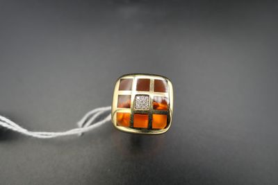 yellow and brown glass bead on a white string on a black surface