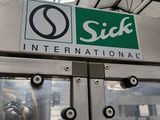 une pancarte sur laquelle on peut lire « Sick International » sur la porte d'un immeuble