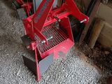 a small red machine that is sitting on the ground