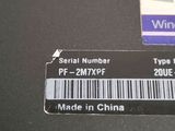two labels on the back of a laptop with a barcode on it
